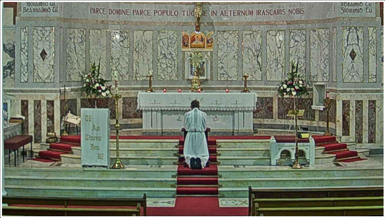 Webcam-Foto vom Innenraum einer Kirche mit einem betenden Priester. Quelle: Watching the World