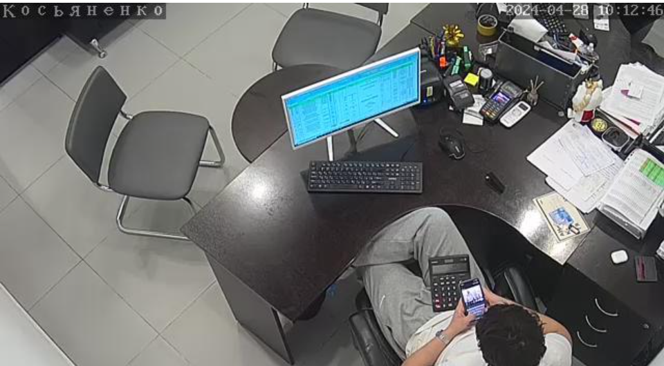 Webcamfoto einer Person am Arbeitsplatz, die am Handy ist. Quelle: Watching the World.