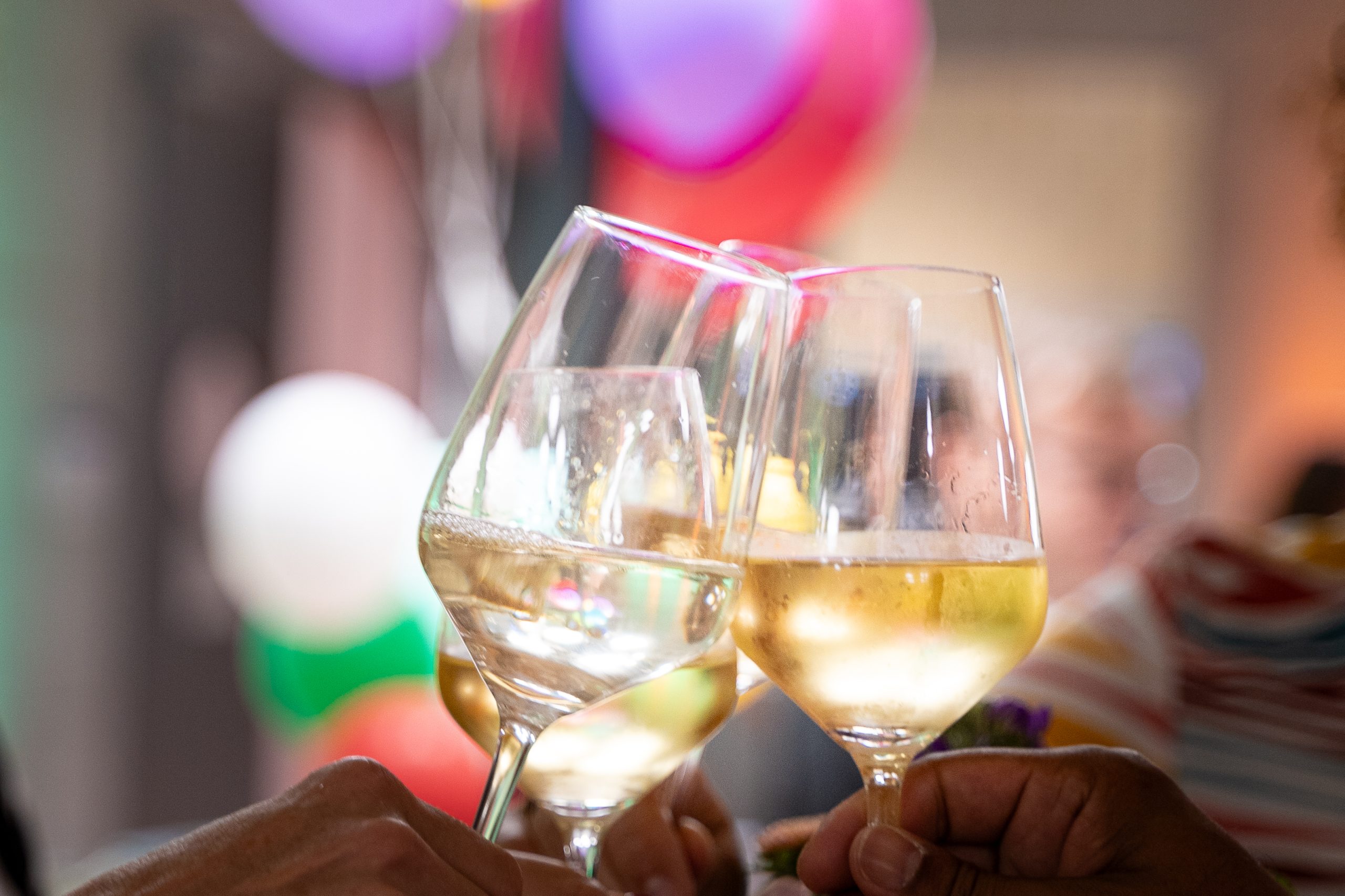 Photo of a toast at an aperitif - three glasses clinking together.