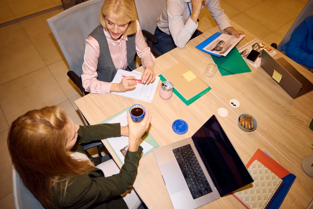 Mehrere Personen sitzen an einem Tisch und führen eine Besprechung durch. 