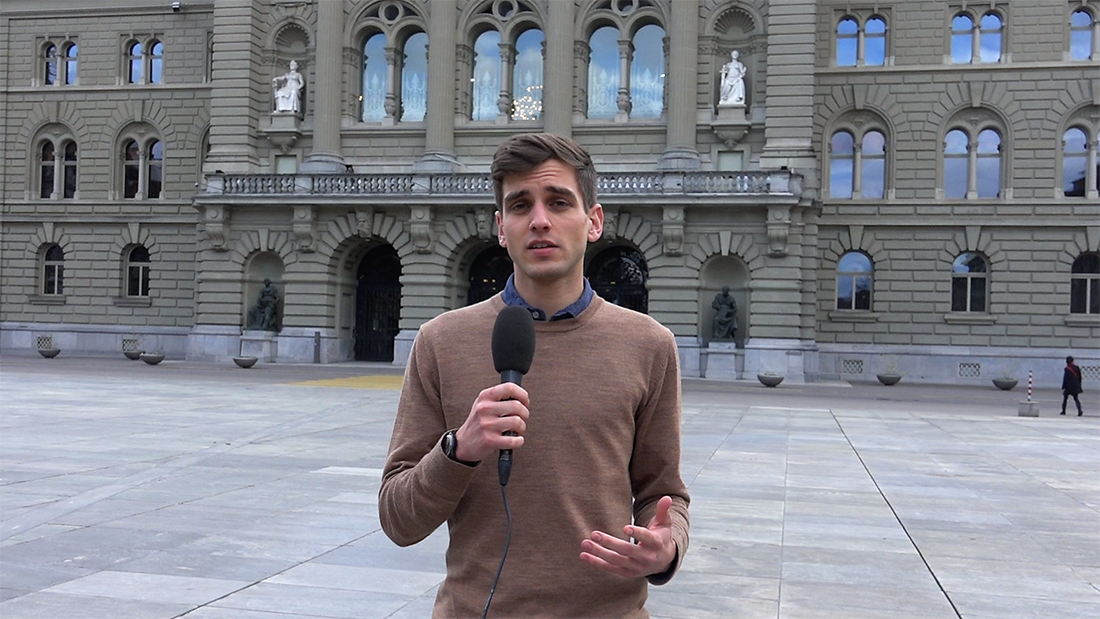Junger Student mit Mikrophon vor dem Bundeshaus in Bern