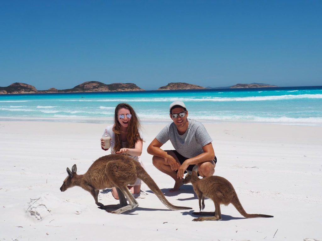 Dalia posiert mit ihrem Mann und einem Getränk in der Hand auf Kangaroo Island mit zwei Kängurus,