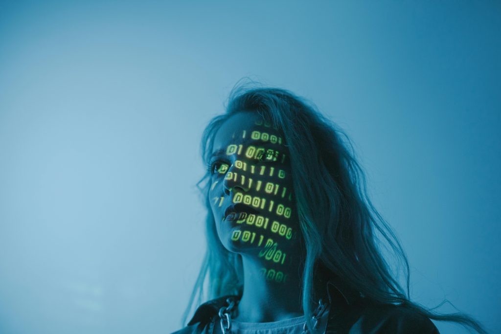 Frau mit projiziertem Zahlencode im Gesicht, Symbolbild Digitalisierung
