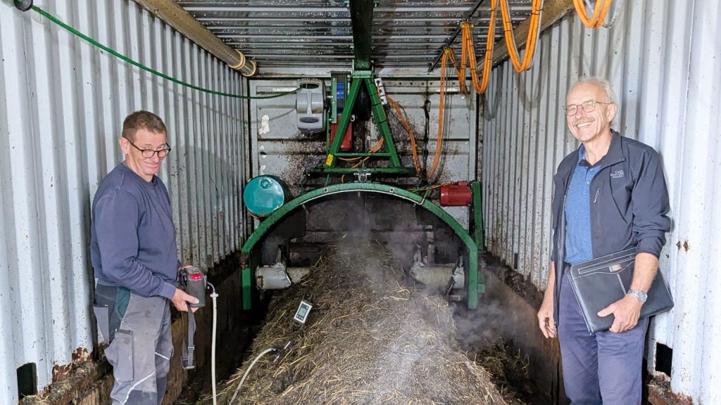 Der Landwirt und ein Forscher der ZHAW beim Kompostiersystem direkt im Stallgebäude