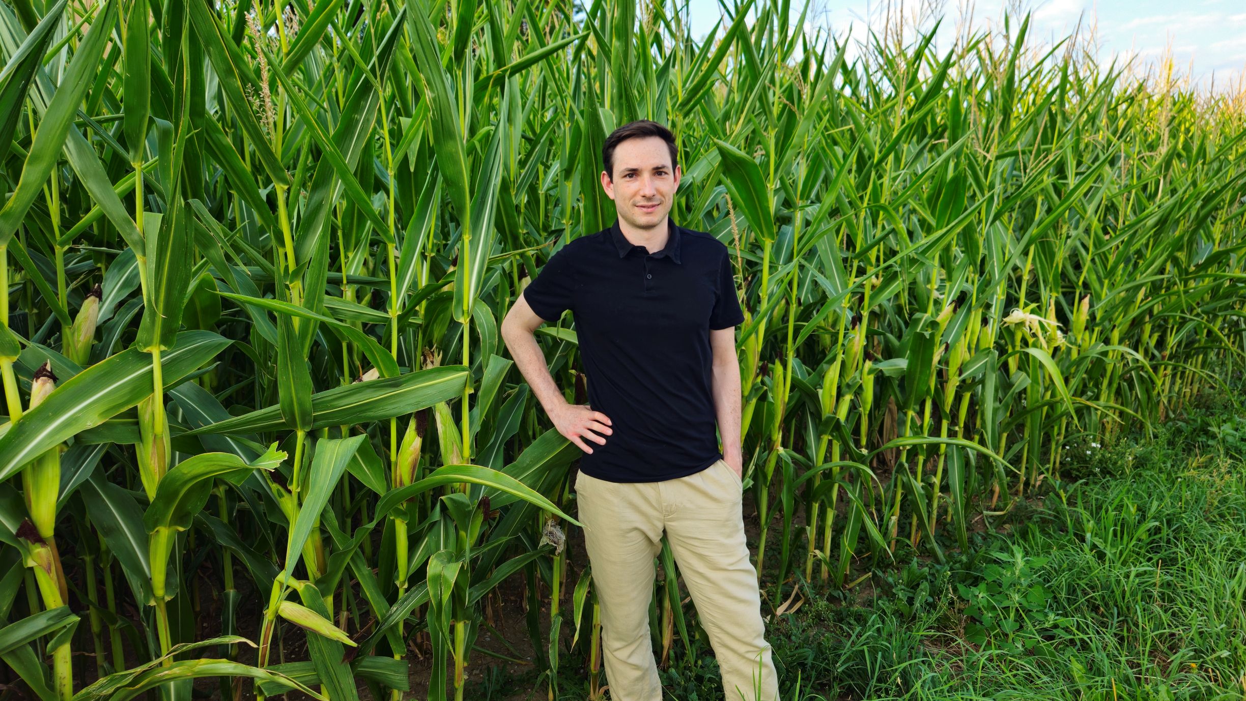 Gregor Mahrer vor einem Maisfeld – ein Sinnbild für seinen Weg ins Umweltingenieurwesen und sein Interesse an nachhaltigen Umwelttechnologien.