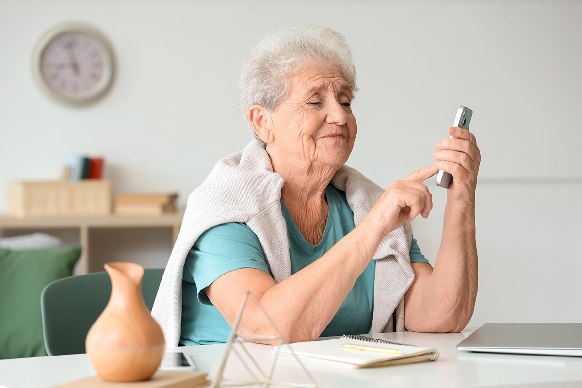 Ältere Frau tippt auf ihr Smartphone